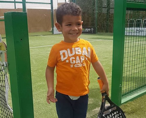 Young boy holding Padel racket.