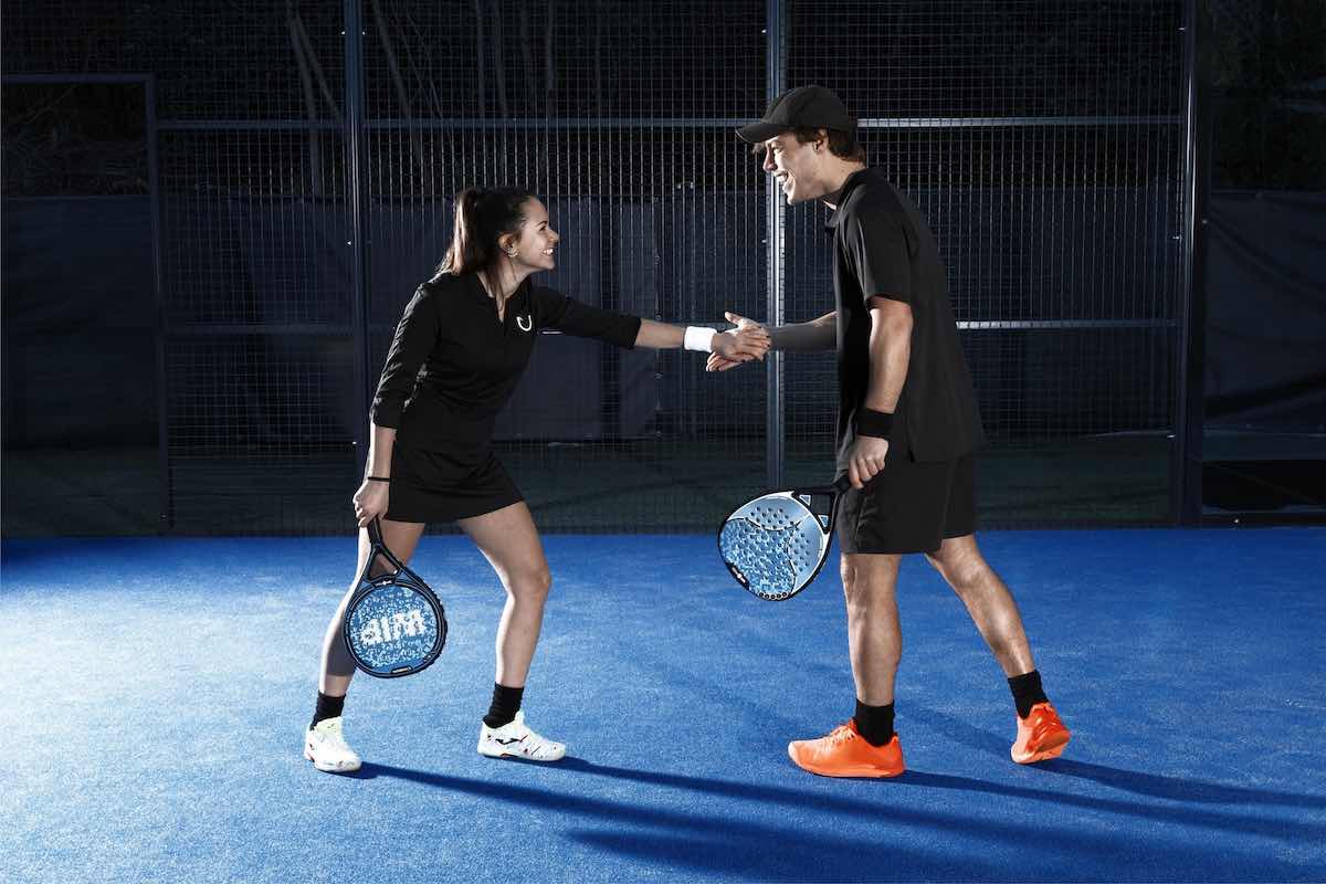 Man and woman agreeing who should play on what side during a padel match.
