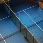 Players on an enclosed glass padel court
