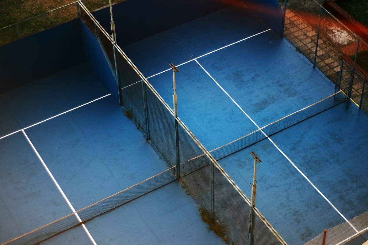 Players on an enclosed glass padel court