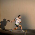 A player on an enclosed squash court